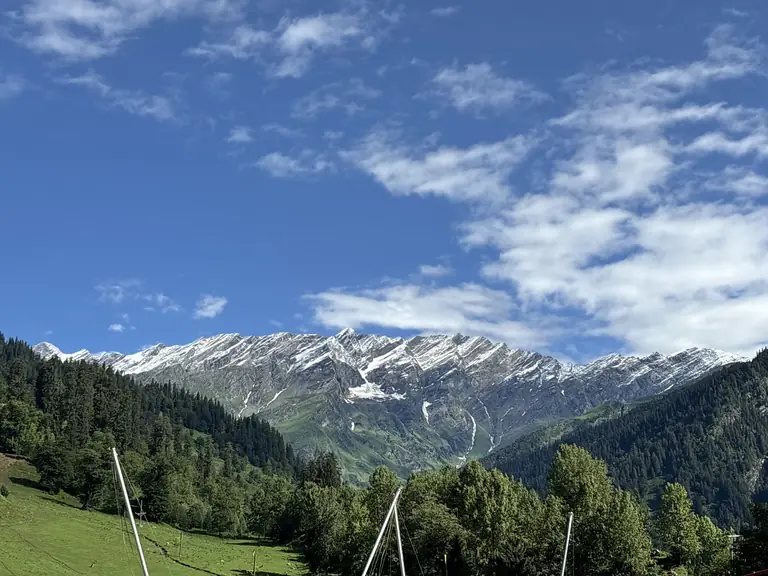 Snow-covered Himalayan mountains above a green Manali valley