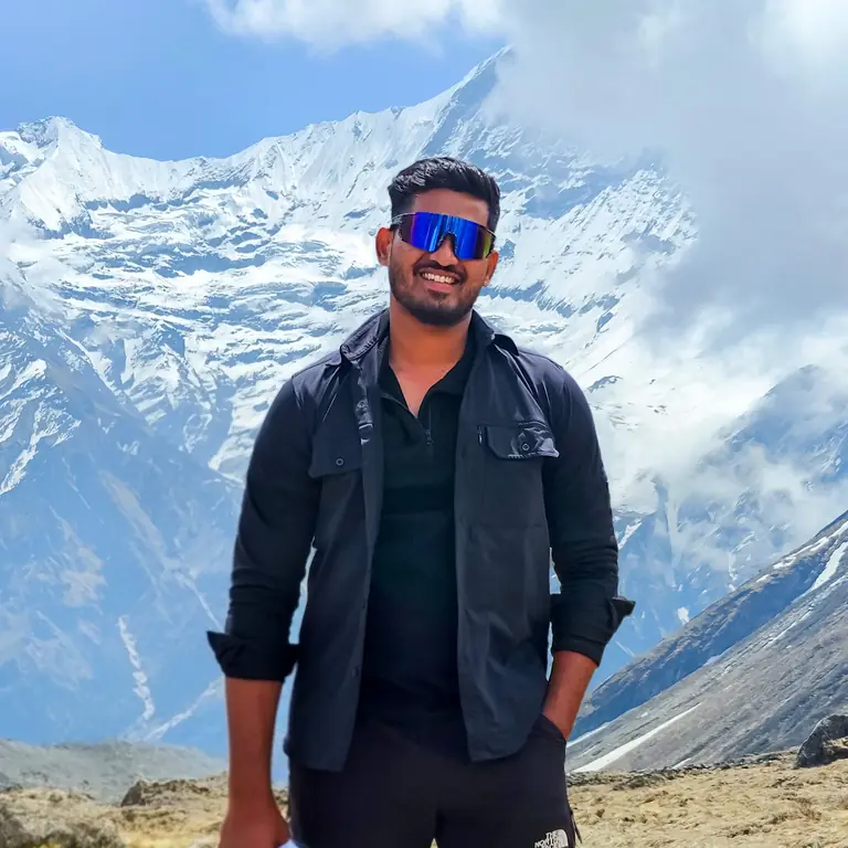Mohan standing in front of snow-covered Himalayan mountains